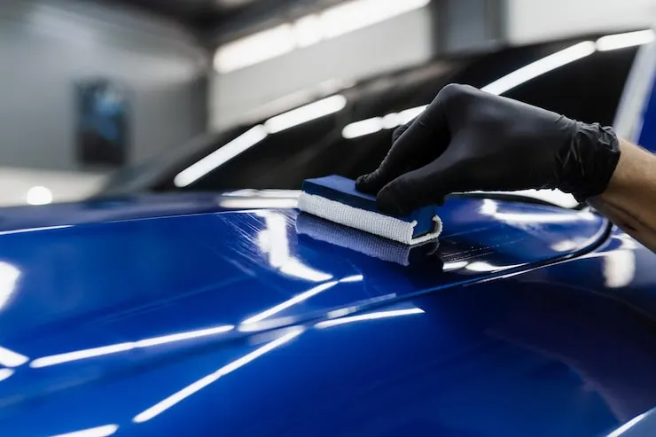 Ceramic coating being applied by hand to the hood of a car at CustomsByAli in Elyria, OH